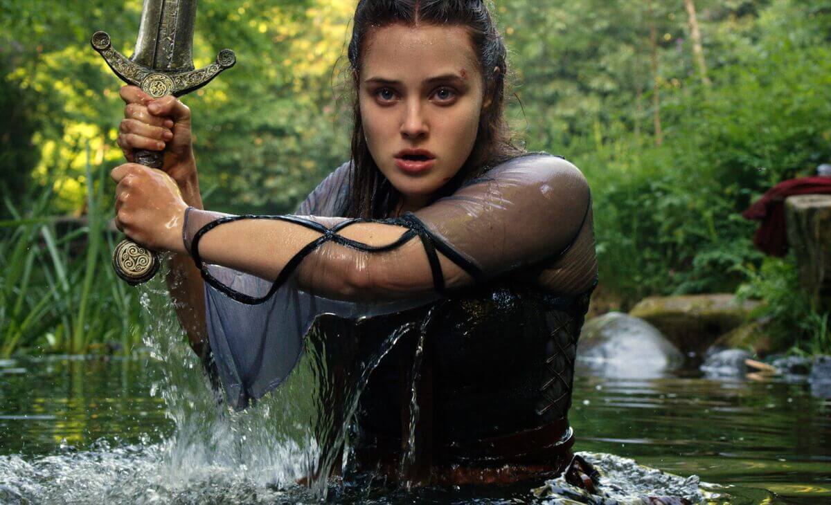 Katherine Langford berada dalam sungai sambil memegang sebuah pedang